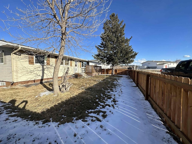 snowy yard featuring fence