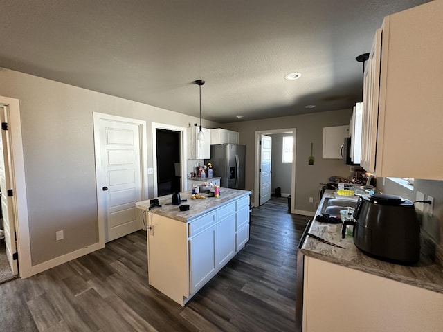 kitchen with dark wood finished floors, stainless steel refrigerator with ice dispenser, and white cabinetry