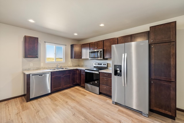 427 Diamond Ridge Blvd, Rapid City, SD 57703 - kitchen with baseboards, a sink, dark brown cabinets, appliances with stainless steel finishes, and light wood-type flooring