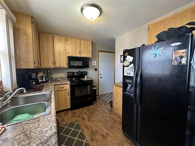 109 David Dr, Sturgis, SD 57785 - kitchen with a sink, a textured ceiling, black appliances, and dark wood finished floors