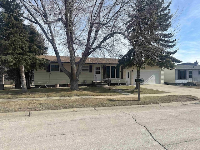 ranch-style house with an attached garage and concrete driveway