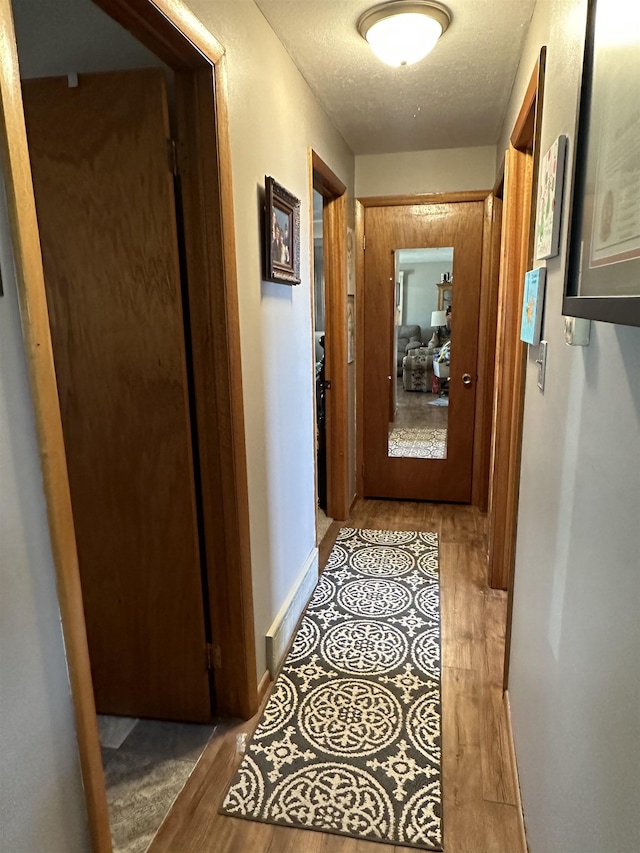 109 David Dr, Sturgis, SD 57785 - hall featuring a textured ceiling, baseboards, and wood finished floors
