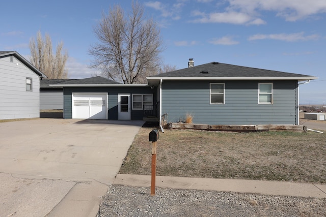 view of front of house featuring an attached garage, driveway, and a shingled roof
