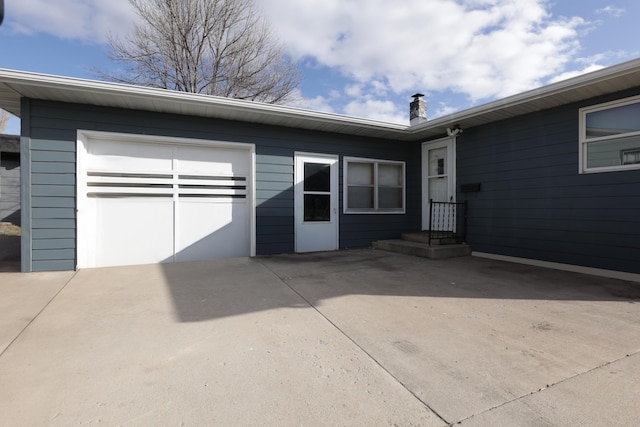view of exterior entry featuring a garage and driveway