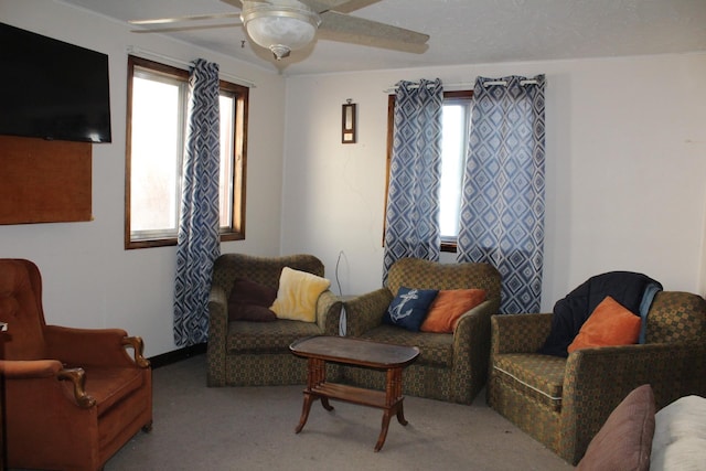 living area featuring a ceiling fan, a wealth of natural light, and carpet floors