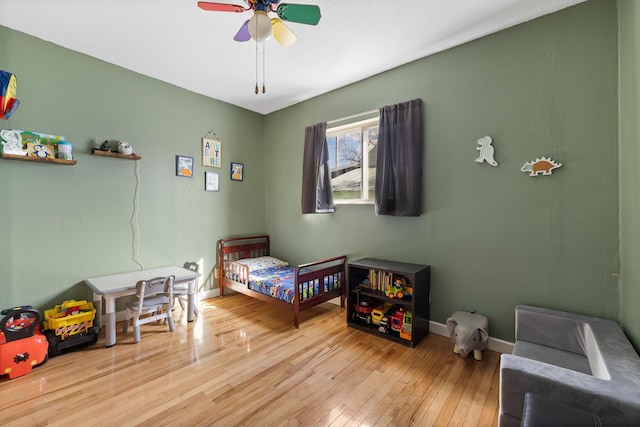 bedroom featuring hardwood / wood-style flooring, baseboards, and ceiling fan