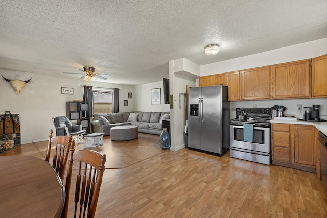 kitchen featuring brown cabinetry, light countertops, stainless steel appliances, and light wood-style floors