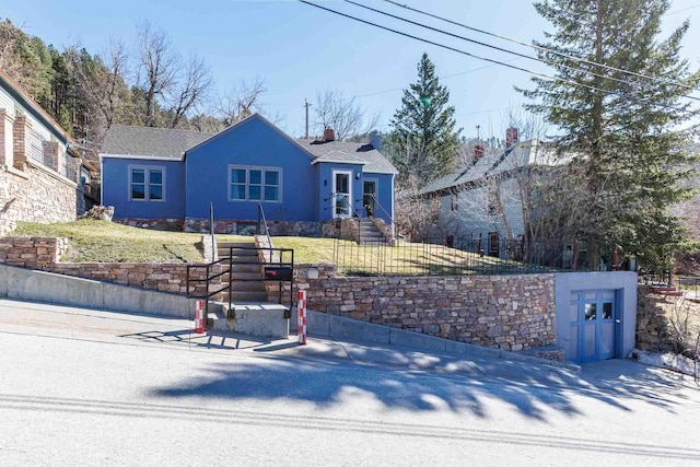 41 Taylor Ave, Deadwood, SD 57732 - view of front facade with stucco siding, a fenced front yard, and a front lawn