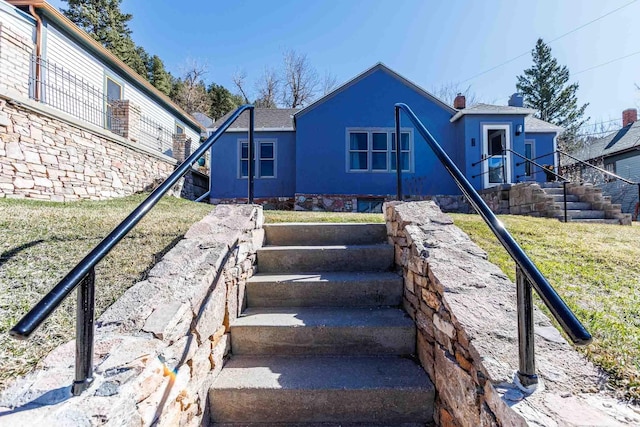 41 Taylor Ave, Deadwood, SD 57732 - rear view of property featuring stucco siding, a chimney, and a lawn