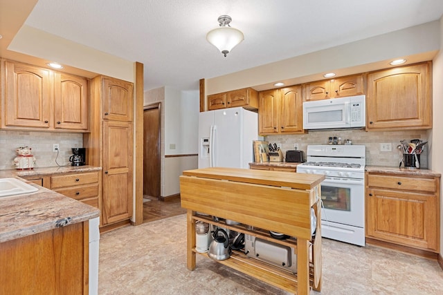kitchen featuring white appliances, wood counters, decorative backsplash, and a sink