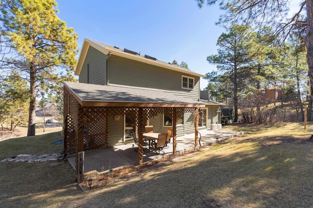 back of property with a lawn and a patio