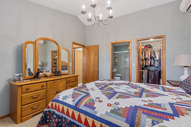 bedroom featuring connected bathroom, a wall mounted AC, a chandelier, a spacious closet, and lofted ceiling