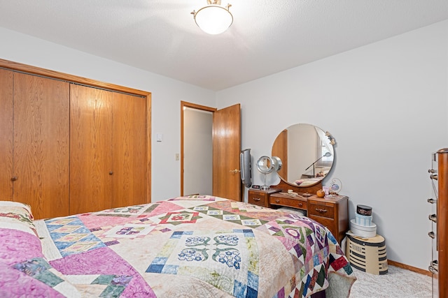 carpeted bedroom with a closet, a textured ceiling, and baseboards