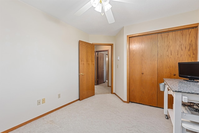 office area with light carpet, baseboards, and ceiling fan