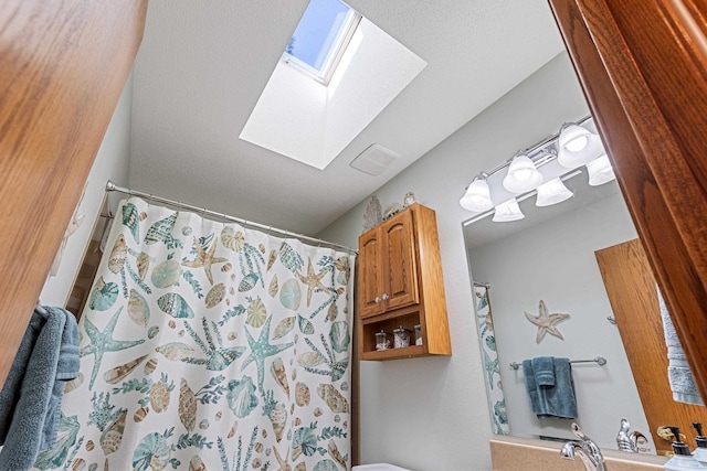 full bathroom featuring a skylight, a shower with shower curtain, and visible vents