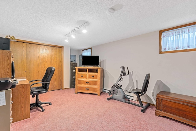 office featuring baseboards, a textured ceiling, track lighting, and light colored carpet