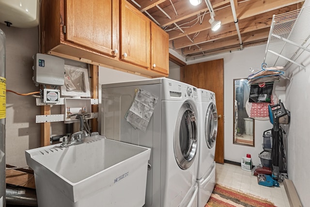 laundry room featuring cabinet space, washing machine and dryer, a sink, and light floors