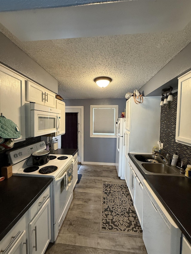4809 Meadow Dr, Black Hawk, SD 57718 - kitchen with a sink, wood finished floors, a textured ceiling, baseboards, and white appliances