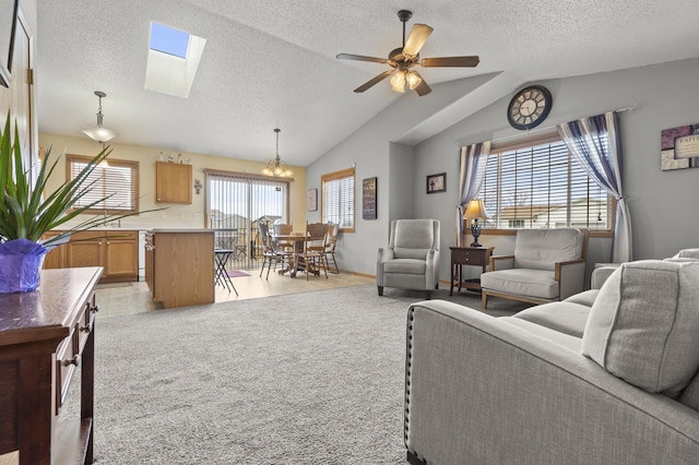 3370 Remington Rd, Rapid City, SD 57703 - living room featuring a textured ceiling, lofted ceiling with skylight, ceiling fan with notable chandelier, and light colored carpet