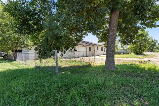 view of yard featuring an attached garage and fence