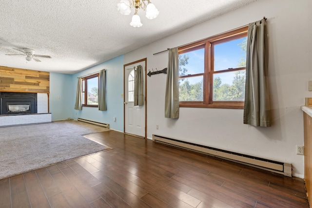 unfurnished living room featuring a textured ceiling, ceiling fan, wood finished floors, and a baseboard radiator