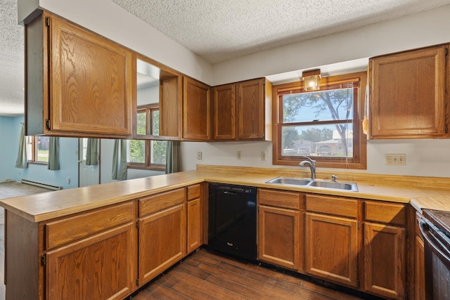 kitchen featuring a sink, a peninsula, baseboard heating, black appliances, and dark wood-style flooring