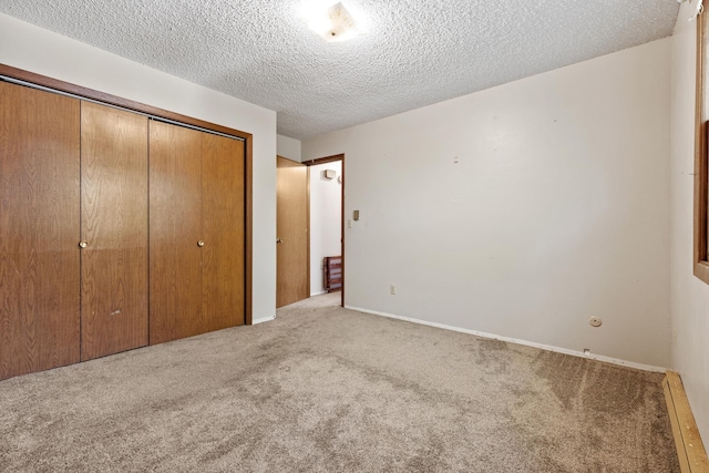 unfurnished bedroom with carpet, a closet, and a textured ceiling