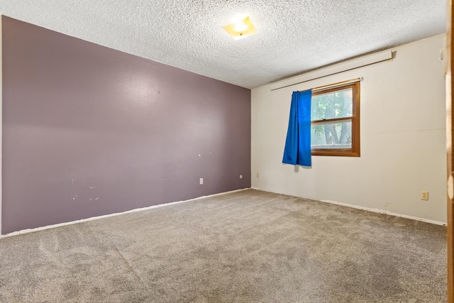 carpeted spare room with a textured ceiling