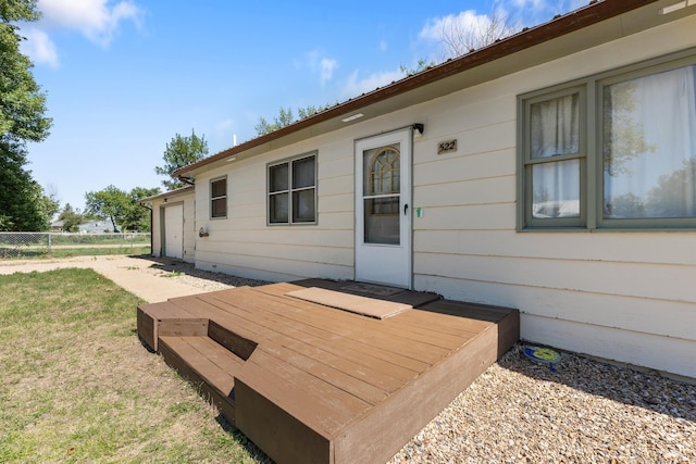 wooden terrace featuring fence and a yard