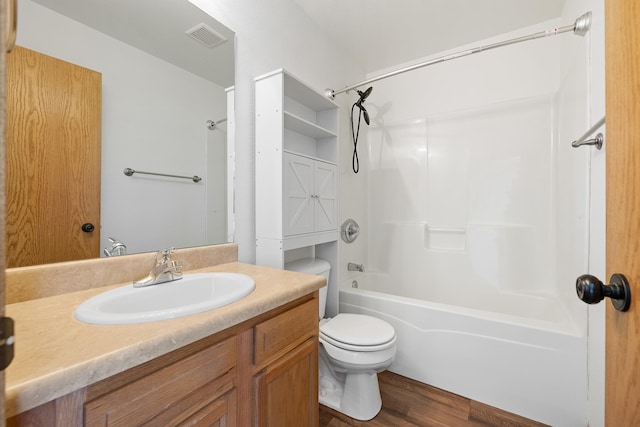 full bath with visible vents, toilet, wood finished floors, vanity, and shower / bath combination