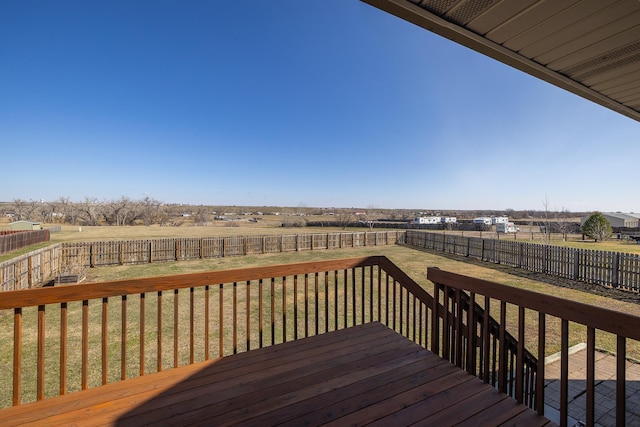 wooden terrace featuring a fenced backyard, a rural view, and a lawn
