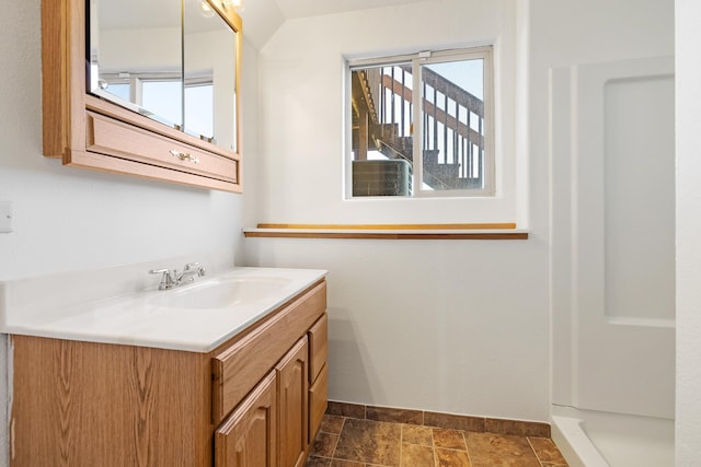 bathroom featuring vanity, stone finish floor, and baseboards