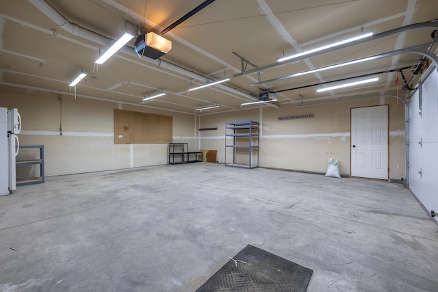 garage with freestanding refrigerator and a garage door opener
