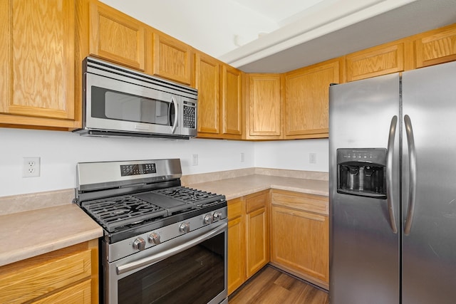 kitchen with light countertops, stainless steel appliances, and wood finished floors