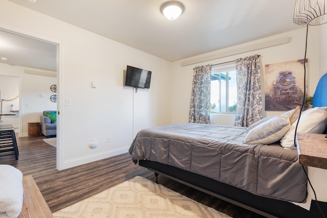 bedroom with baseboards and wood finished floors