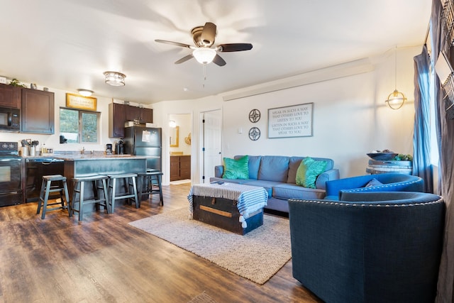 living room with a ceiling fan and dark wood finished floors