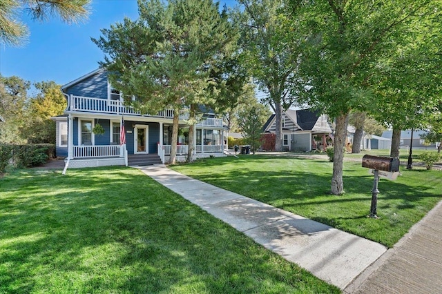 view of front of home featuring covered porch, a front yard, and a balcony