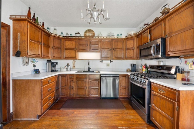 kitchen with stainless steel appliances, brown cabinetry, and a sink