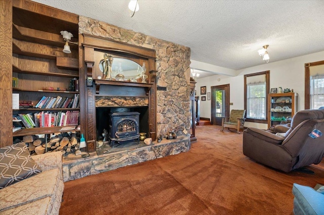 living room featuring a wood stove, carpet, and a textured ceiling