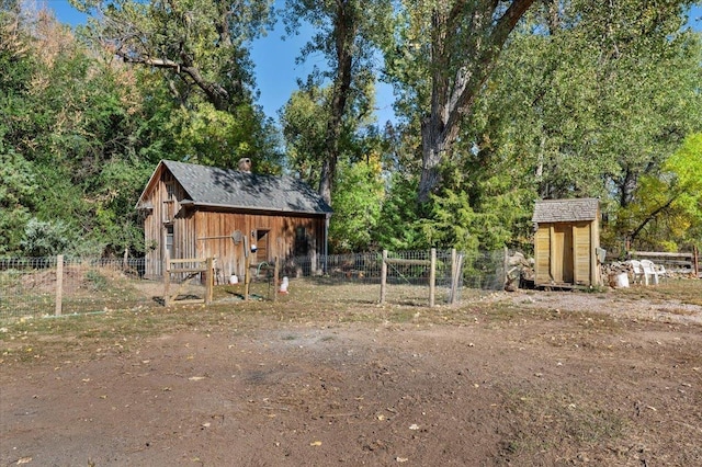 view of yard featuring an outdoor structure, fence, and a storage unit