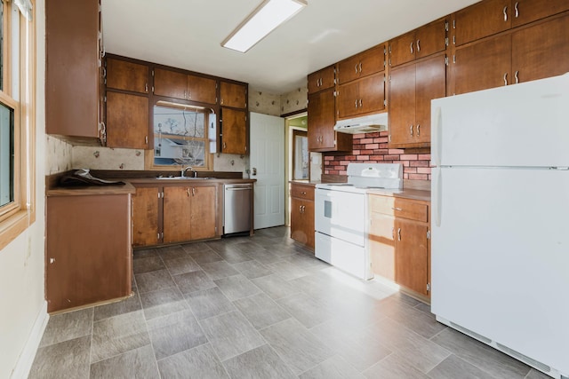 1227 S Street, Rapid City, SD 57701 - kitchen featuring under cabinet range hood, white appliances, brown cabinets, and a sink