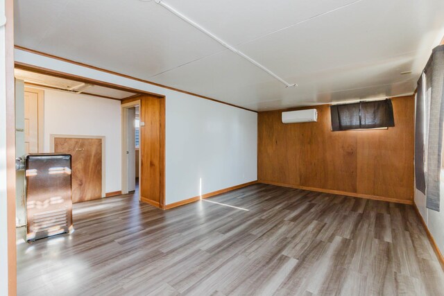 1227 S Street, Rapid City, SD 57701 - finished below grade area featuring wooden walls, baseboards, a wall unit AC, and wood finished floors