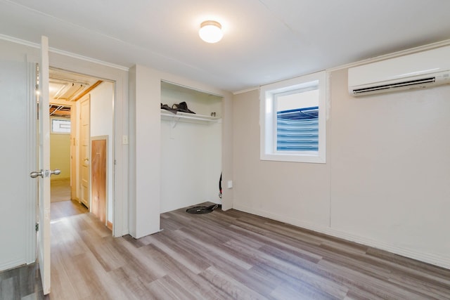1227 S Street, Rapid City, SD 57701 - unfurnished bedroom featuring a wall mounted AC, light wood finished floors, and a closet