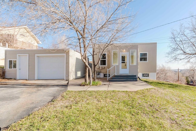 1227 S Street, Rapid City, SD 57701 - view of front facade with stucco siding, an outdoor structure, driveway, a front lawn, and a garage