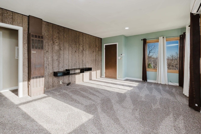 1227 S Street, Rapid City, SD 57701 - unfurnished living room featuring baseboards, a wall unit AC, and carpet floors