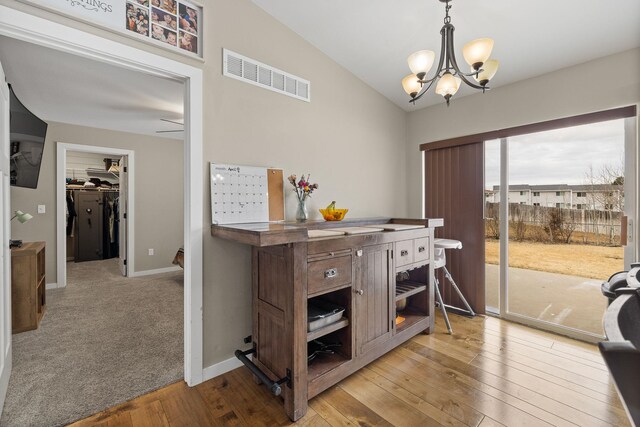 1914 7th Ave, Belle Fourche, SD 57717 - dining space featuring baseboards, vaulted ceiling, a chandelier, light wood-style flooring, and visible vents