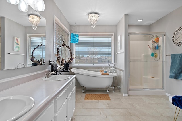 bathroom with an inviting chandelier, tile patterned floors, a sink, and a stall shower