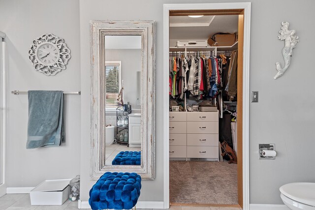 bathroom featuring a walk in closet and toilet