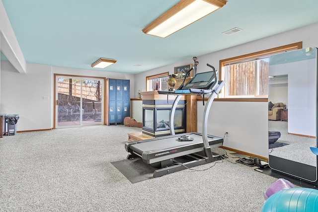 exercise room with baseboards, carpet flooring, visible vents, and a wealth of natural light