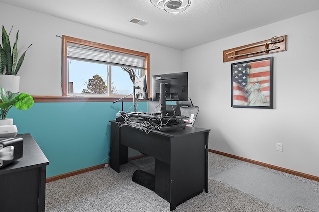 carpeted office space featuring baseboards and visible vents